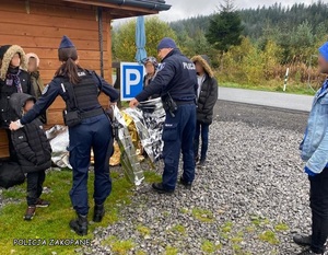 policjanci w dolince pomagają uchodźcom