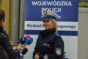 Policjanta ruchu drogowego udzialająca wywiadu na stacji diagnostycznej dziennikarzom z wielu różnych stacji