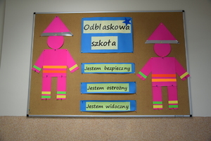 tablica ogłoszeń z napisem odblaskowa szkoła i różowymi postaciami po bokach