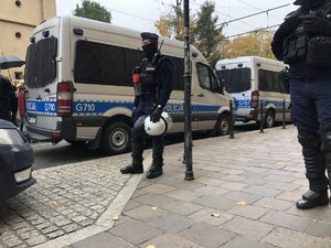 policjant prewencji przy radiowozie podczas zabezpieczenia zgromadzenia