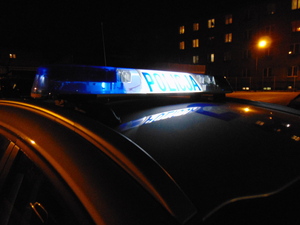 Radiowóz na tle bloków w nocy