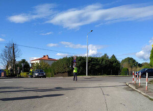 Policjant ruchu drogowego kieruje ruchem na skrzyżowaniu