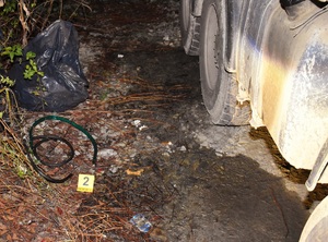 bak samochodu ciężarowego i na ziemi położony wężyk do spuszczania paliwa