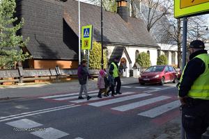 przedszkolaki pod okiem policjanta przechodzą przez przejście dla pieszych