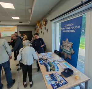 Dzień seniora; policjantka rozmawia z seniorami na stoisku