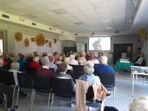 Dzień seniora Seniorzy siedzą na krzesełkach i oglądają filmy profilaktyczne