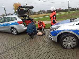 Akcja Żyj i ratuj życie w Jawiszowicach nauczyciel ratownictwa pokazuje resuscytację kierowcy obok stoi uczennica