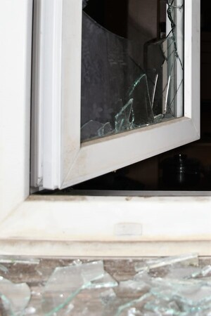 Wybita szyba w kwaterze okiennej, rozbite szkła na parapecie