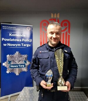 policjant trzyma w ręce puchar