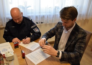 Komendant Powiatowy Policji oraz Wój Gminy podpisują porozumienie przy stole