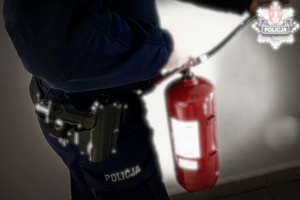 policjant trzyma w ręce gaśnice
