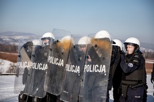 policjanci z tarczami spryskani gazem