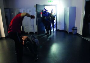 policjanci wbiegają do pomieszczenia, gdzie trwa bójka dwóch osób