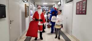 mikołajkowy orszak przemierzający korytarz szpitala w celu wręczenia podarunków dzieciom
