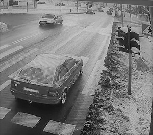 Zaśnieżony opel jedzie ulicą w tle inne pojazdy