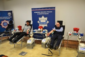 nieumundurowany policjant i młody mężczyczna oddają krew