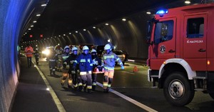 strażacy niosący poszkodowanego w tunelu