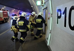 strażacy wnoszący poszkodowanych w bezpieczne miejsce