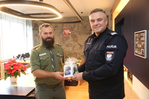 Komendant przekazuje harcerzowi pamiątkową bombkę