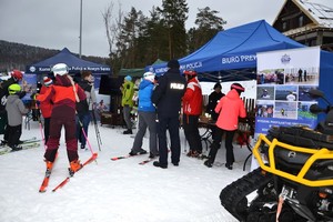 narciarze przy stoiskach promocyjnych Policji-  inauguracja akcji Kręci mnie Bezpieczeństwo na stoku w Krynicy- Zdroju