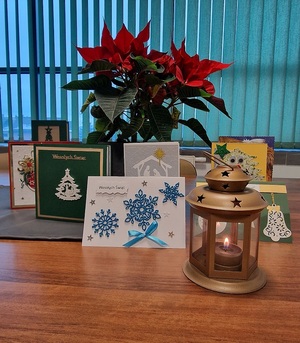 lampion kwiat i kartwki świąteczne na stole