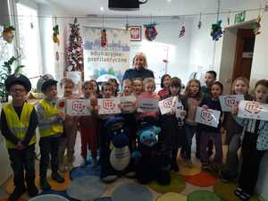 pamiątkowe zdjęcie uczestników z policjantką i maskotkami policyjnymi