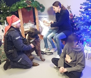 policyjny przewodnik z psem, obok dwoje dzieci z wychowawczynią