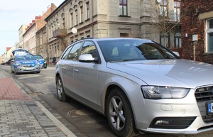 KPP Oświęcim. Audi oraz radiowóz na ulicy