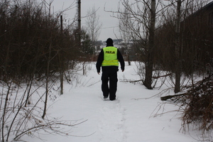 zdjęcie prezentujące policjanta idącego w  kierunku pustostanu