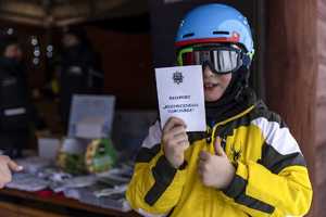 młody narciarz prezentuje paszport bezpiecznego narciarza