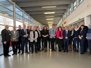 Członkowie małopolskiej wojewódzkiej rady bezpieczeństwa ruchu drogowego  stoją na korytarzu ustawieni do zdjęcia