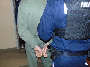 Policjant oraz zatrzymany z kajdankami na rękach