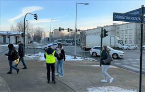 policjantka przypominająca pieszym zasady bezpiecznego poruszania się po drodze