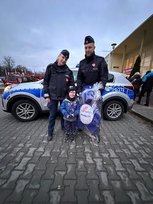 policjanci z dzieckiem i inspektorem wawelkiem policyjną maskotką
