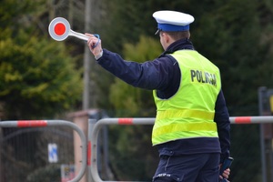 Policjant ruchu drogowego zatrzymujący pojazda tarczą do zatrzymywania pojazdów