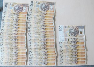 rozłożona na biurku gotówka w banknotach 200 złotowych.