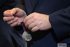 ręka trzymająca medal przed przypięciem
