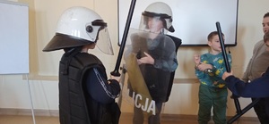 dzieci przymierzające przymierzyć strój policjantów biorących udział w zabezpieczeniach