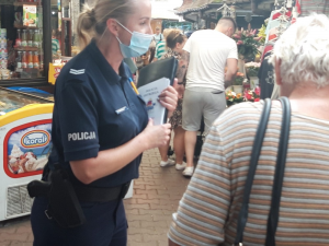 policjantka na placu targowym rozmawia z kobietą o zagrożeniach