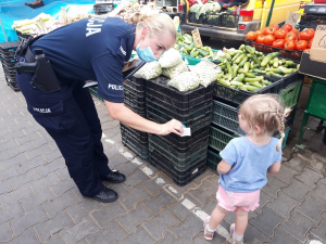 policjantka wręcza małej dziewczynce odblask