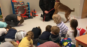 przewodnik psa służbowego wraz ze swoim czworonogiem uczy dzieci właściwej pozycji żółwia, podczas ataku agresywnego psa