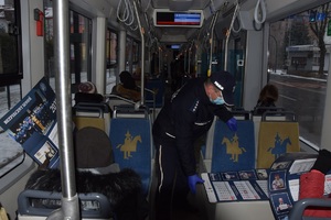 Policjant w tramwaju rozdający kalendarze podróżnym.