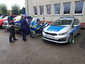 policjanci stojący przy pojazdach służbowych